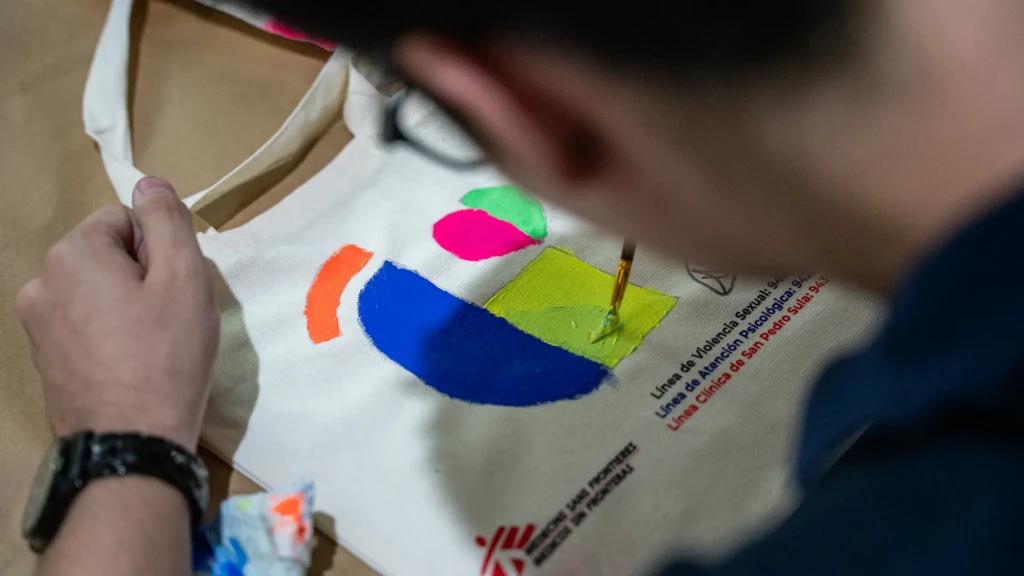 Paciente de MSF, pinta una bolsa de tela como parte de las celebraciones que conmemoran los cuatro años de trabajo de MSF en la clínica de San Pedro Sula. © Fritz Pinnow Kawas/MSF