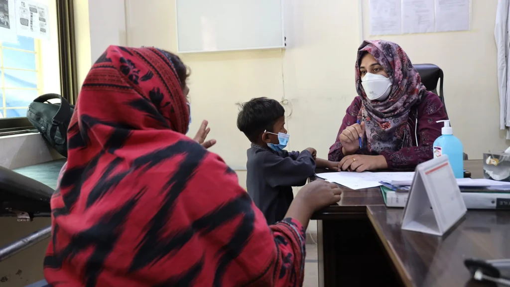 La doctora Hafsa Fatima conversa con la madre de Anosh, de cuatro años, durante una consulta en la clínica pediátrica, donde el equipo de MSF atiende a todos los niños menores de 14 años de las familias de los pacientes registrados en el centro. Gujranwala, Pakistán, febrero de 2026.