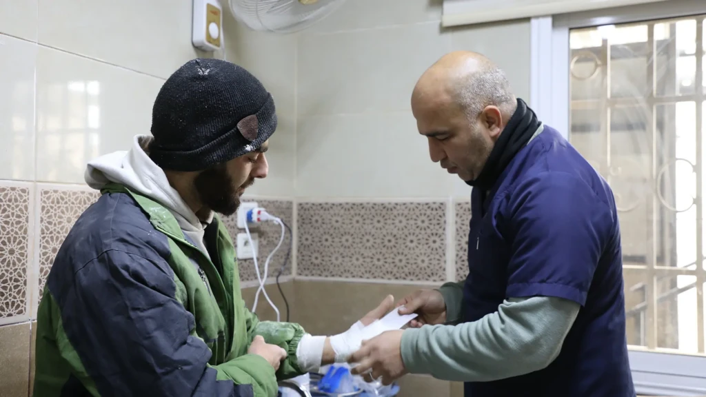 Un enfermero de la sala de urgencias del Centro de Atención Primaria de Salud Al-AL-Khalediyah realiza una cura rutinaria a uno de los pacientes que acuden al centro.