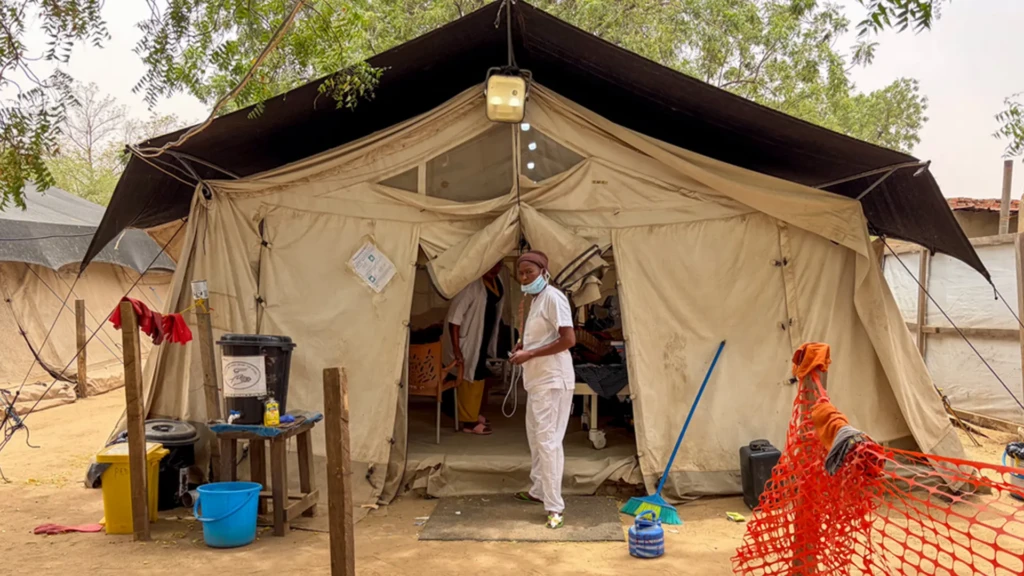 Mujeres y niños se reúnen en un punto de vacunación en un asentamiento de refugiados en Adré, donde el hacinamiento y la inmunización rutinaria limitada aumentan el riesgo de transmisión del sarampión. Asentamiento de refugiados, Adré, provincia de Ouaddaï, Chad.