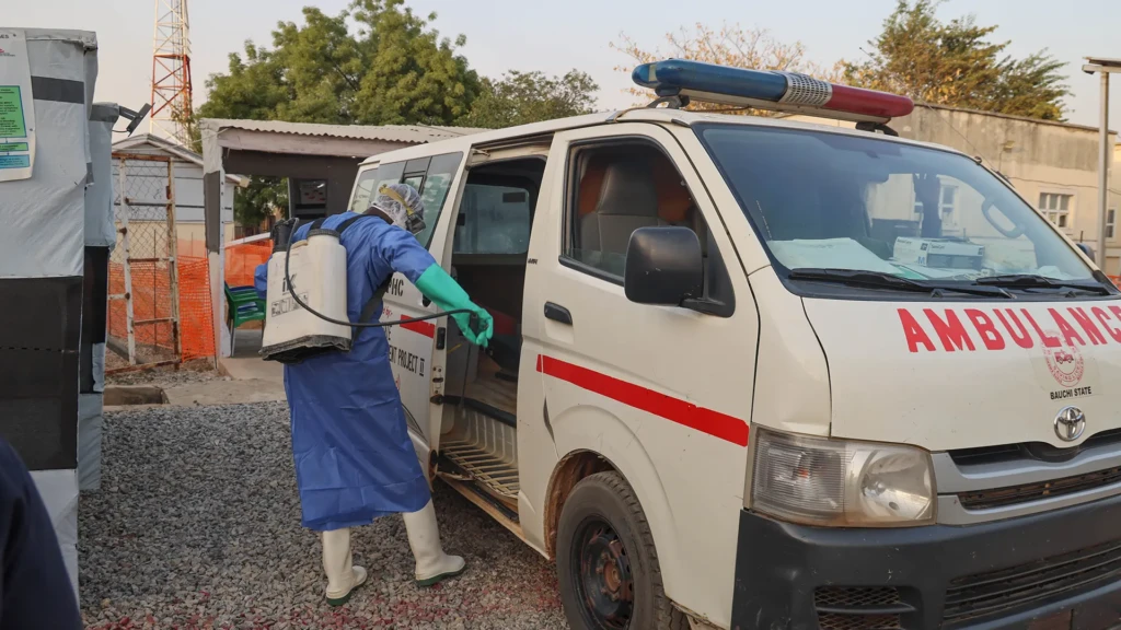 Un agente de higiene desinfecta una ambulancia que acaba de traer a un paciente sospechoso de fiebre de Lassa al centro de tratamiento de fiebre de Lassa. Bauchi, Nigeria.