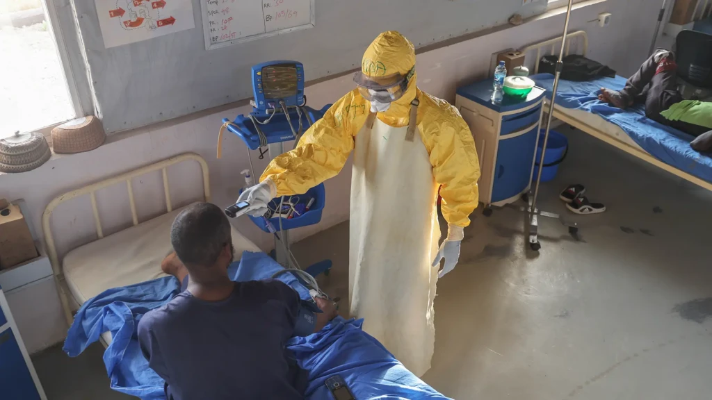 Una enfermera que toma la temperatura de un paciente ingresado por fiebre de Lassa en el centro de tratamiento de fiebre de Lassa, apoyado por MSF. © Abba Adamu Musa/MSF