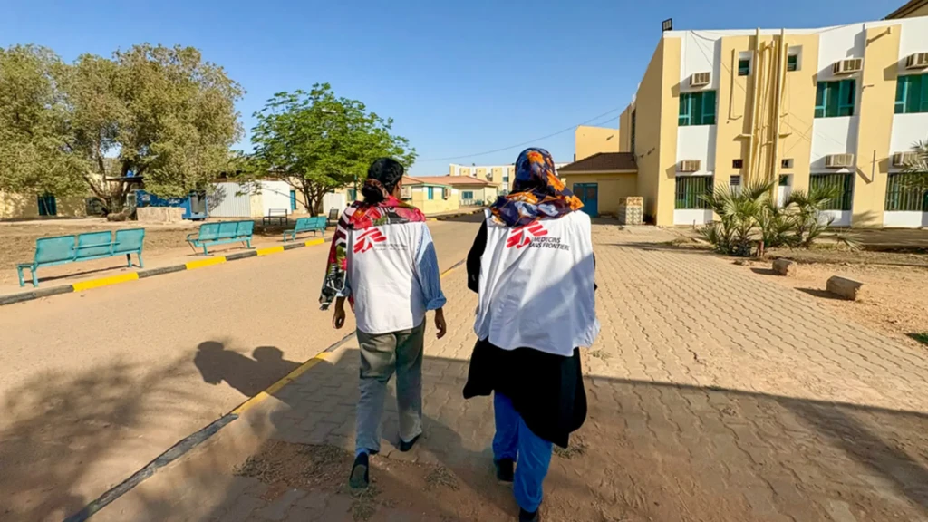 Dos miembros del personal de MSF están caminando por el recinto del Hospital Universitario.