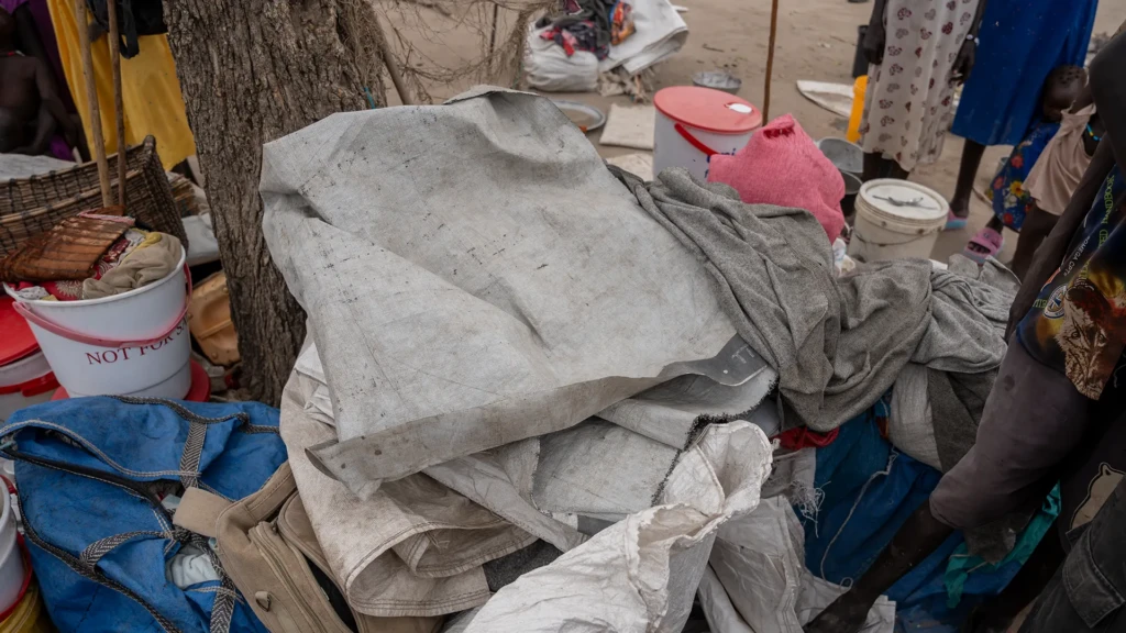 Las pertenencias que Nyaruop Machar llevaba cuando huyó de Nyatim se ven bajo un árbol en Yakuach, donde ahora se refugia con su familia tras ser desplazada por la violencia.