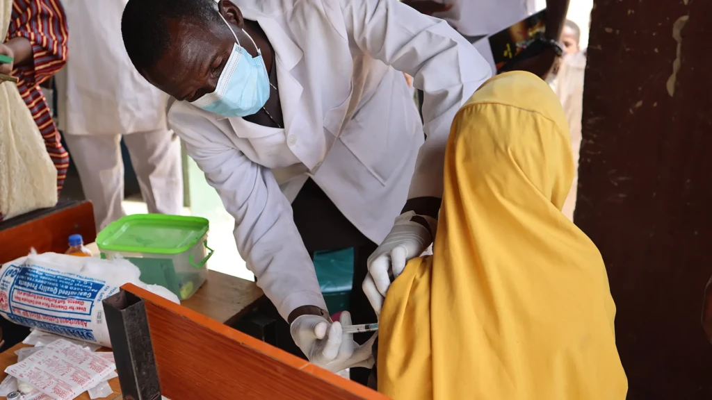 Personal del Ministerio de Salud administra una vacuna contra la difteria a una mujer en una escuela primaria de la ciudad de Durum, en el distrito de Kundun Durum.