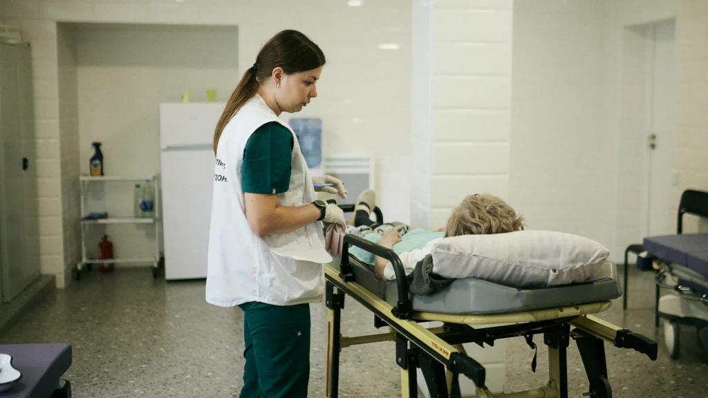 Hanna Dudnyk, médica de urgencias de MSF, examina a Svitlana, de 67 años, que fue trasladada a urgencias en ambulancia con quejas de pérdida de conocimiento y dolor intenso.