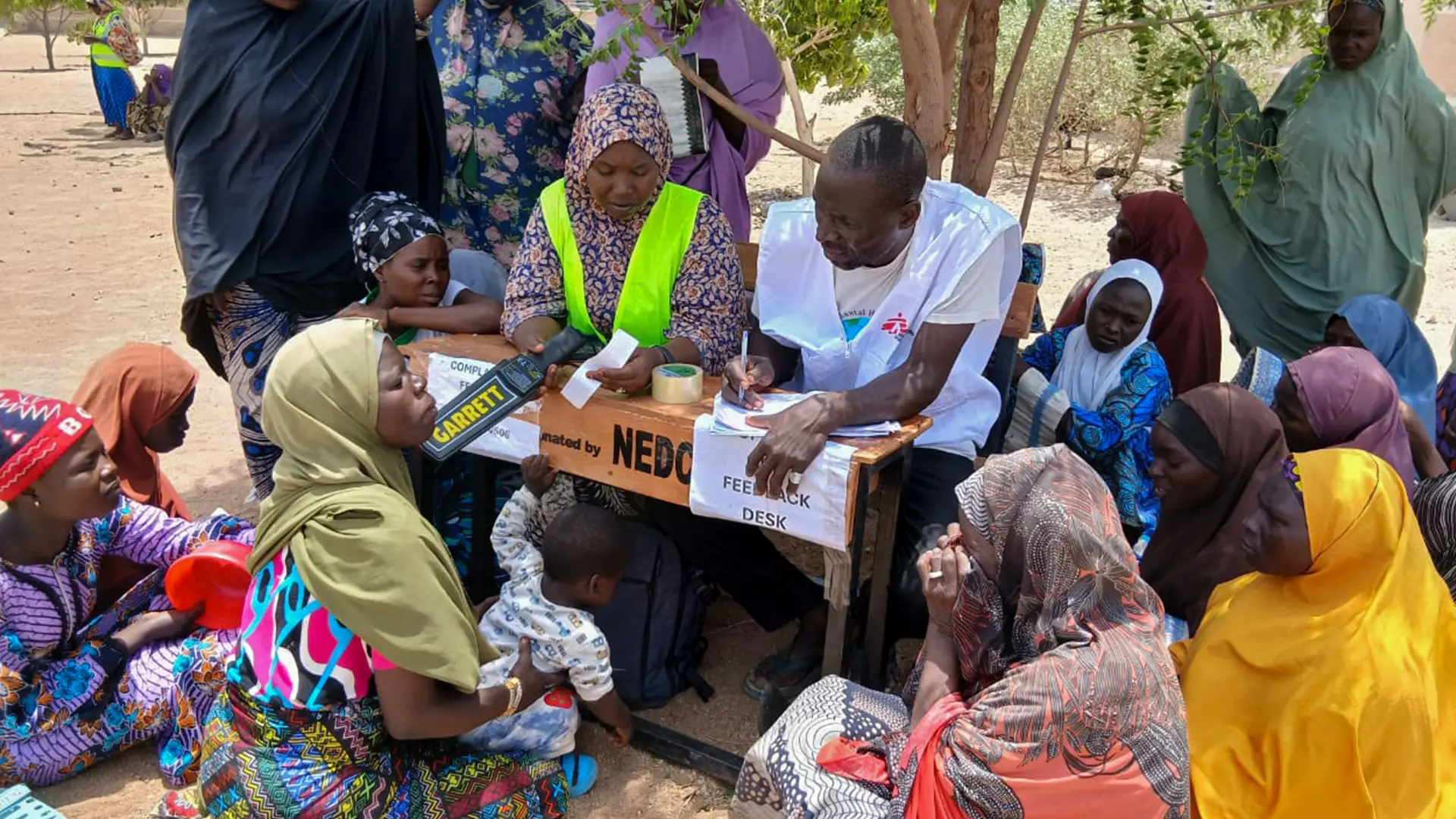 Personas desplazadas de Ngoshe se reúnen en un punto de información de MSF durante la distribución de paquetes de ayuda no alimentaria, en Pulka, Borno, Nigeria.