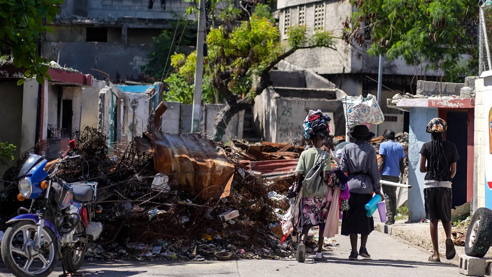 Haití: una crisis mayor, multifacética y sin financiación Los residentes rodean los restos de una barricada, en el barrio de Solino, Puerto Príncipe. A principios de 2024, un grupo armado tomó el control de la zona y la vació de su población.