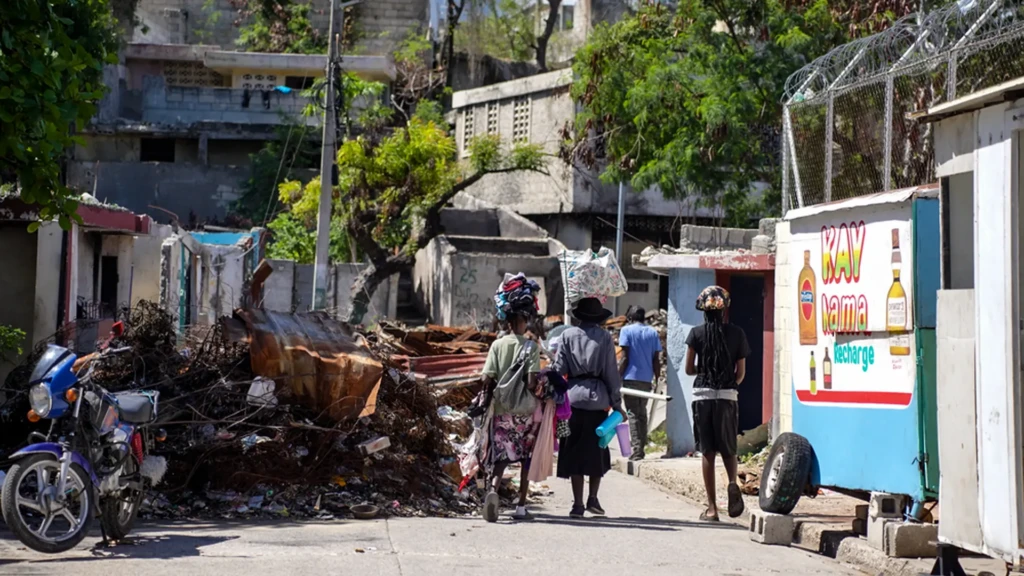 Habitantes que caminan alrededor de las ruinas de una barricada en el barrio de Solino, en Puerto Príncipe. © Marx Stanley Léveillé/MSF