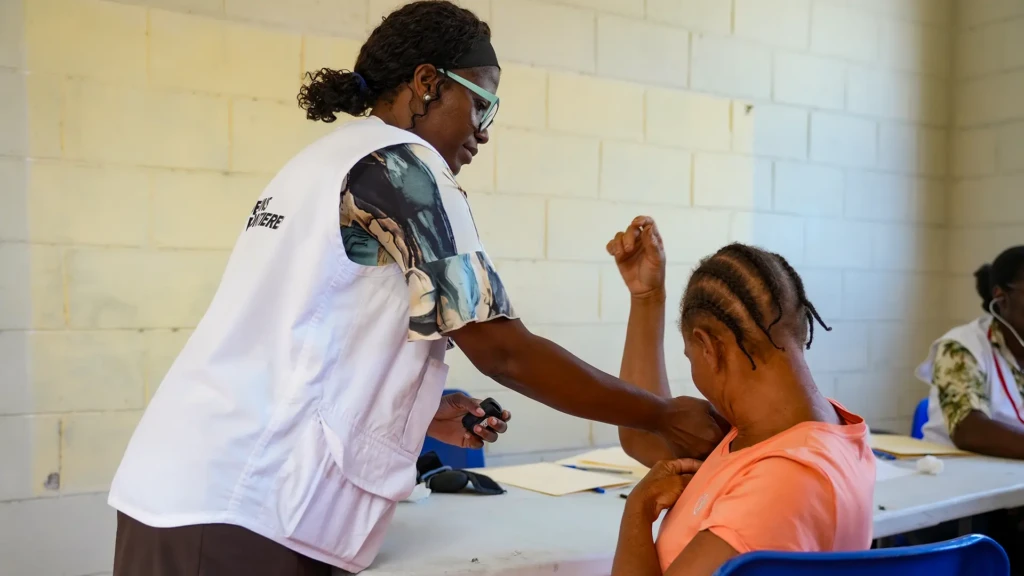 Darline, enfermera, examina a un paciente en una clínica móvil de MSF en el barrio de Solino. Con operaciones varias veces a la semana, la clínica tiene como objetivo ofrecer consultas médicas gratuitas a los residentes de la zona donde no hay otros servicios disponibles.