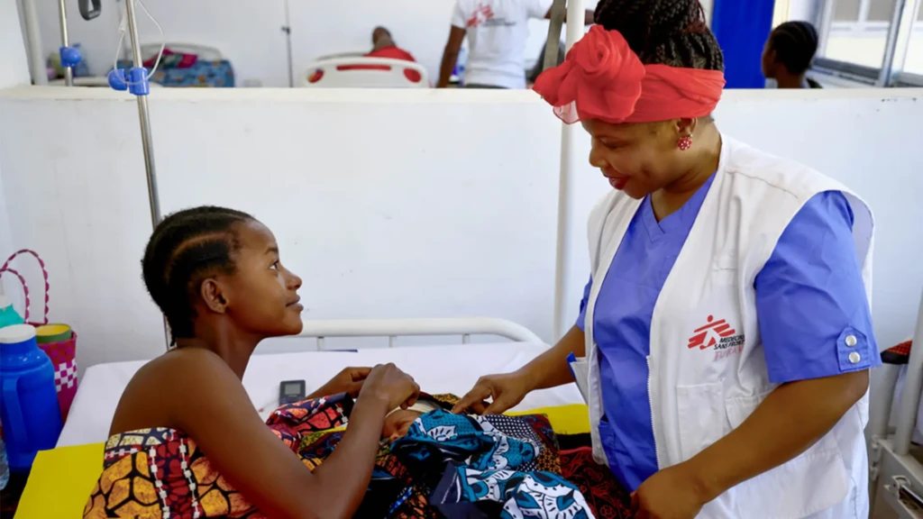 Furaha Walumpupu, responsable de actividades de matronas, junto a una madre joven en la sala de maternidad del hospital Liwale B, en Tanzania, donde recientes recortes de ayuda han reducido la cobertura de servicios esenciales de salud sexual y reproductiva.