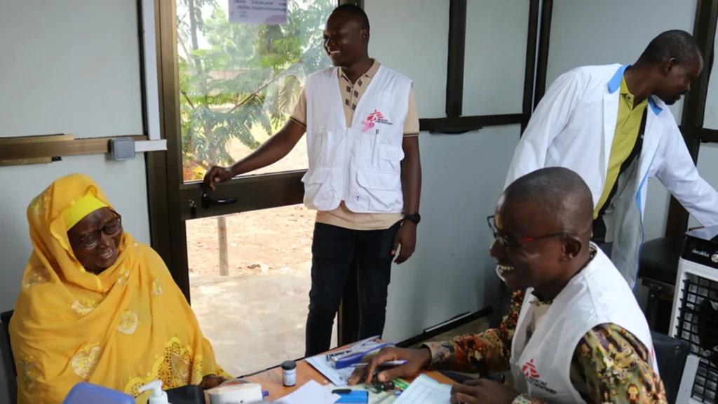Djibril Ouedraogo, supervisor de enfermería, y sus colegas ayudan a un paciente a controlar su enfermedad no transmisible en la sala de tratamiento especializada en Dédougou, Burkina Faso.