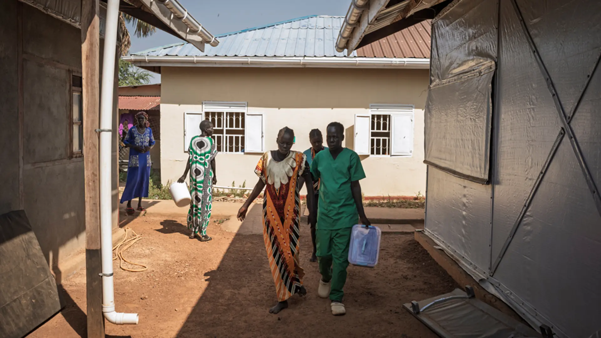 Una partera guía a Nyariak Lual, de 19 años, en las primeras fases del parto hacia la unidad materna del hospital de Mayen Abun, en Sudán del Sur.