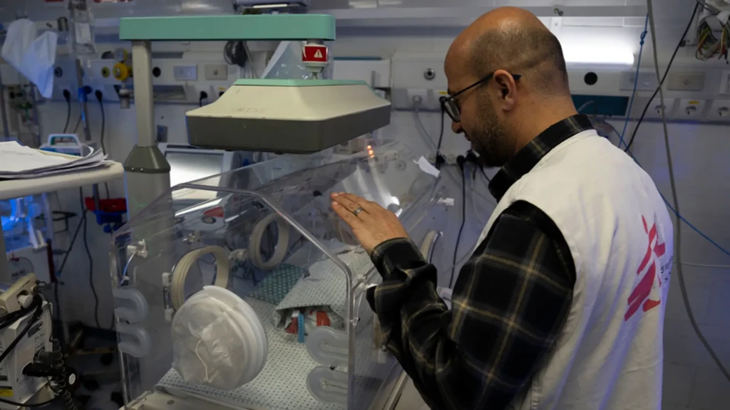 Mohammed Shehada, jefe de actividades de enfermería de MSF en el hospital Al-Helou, en la ciudad de Gaza, examina a un recién nacido con bajo peso que yace en una incubadora.