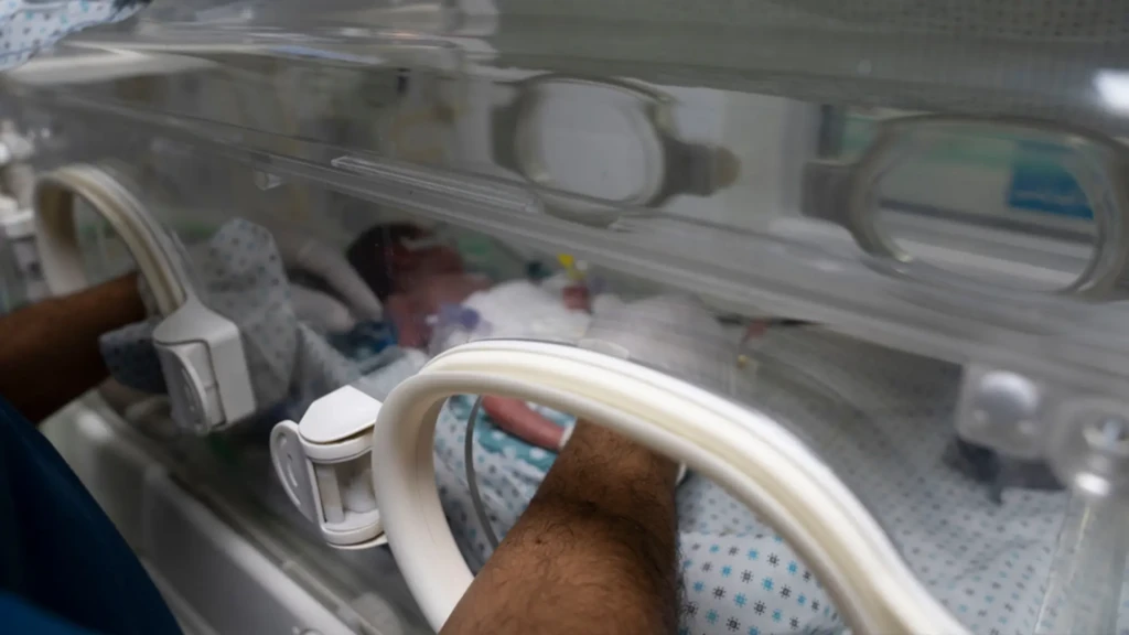 Un miembro del personal del hospital Al-Helou, en la ciudad de Gaza, territorio palestino ocupado, revisa a un recién nacido con bajo peso que yace en una incubadora.