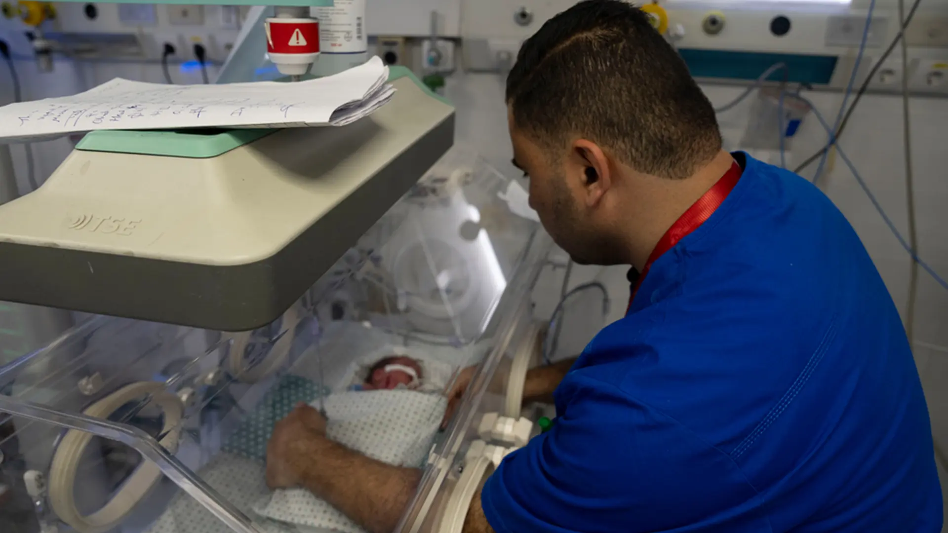 Un miembro del personal del hospital Al-Helou, en la ciudad de Gaza, revisa a un recién nacido con bajo peso que yace en una incubadora. Gaza, Palestina, abril de 2026.