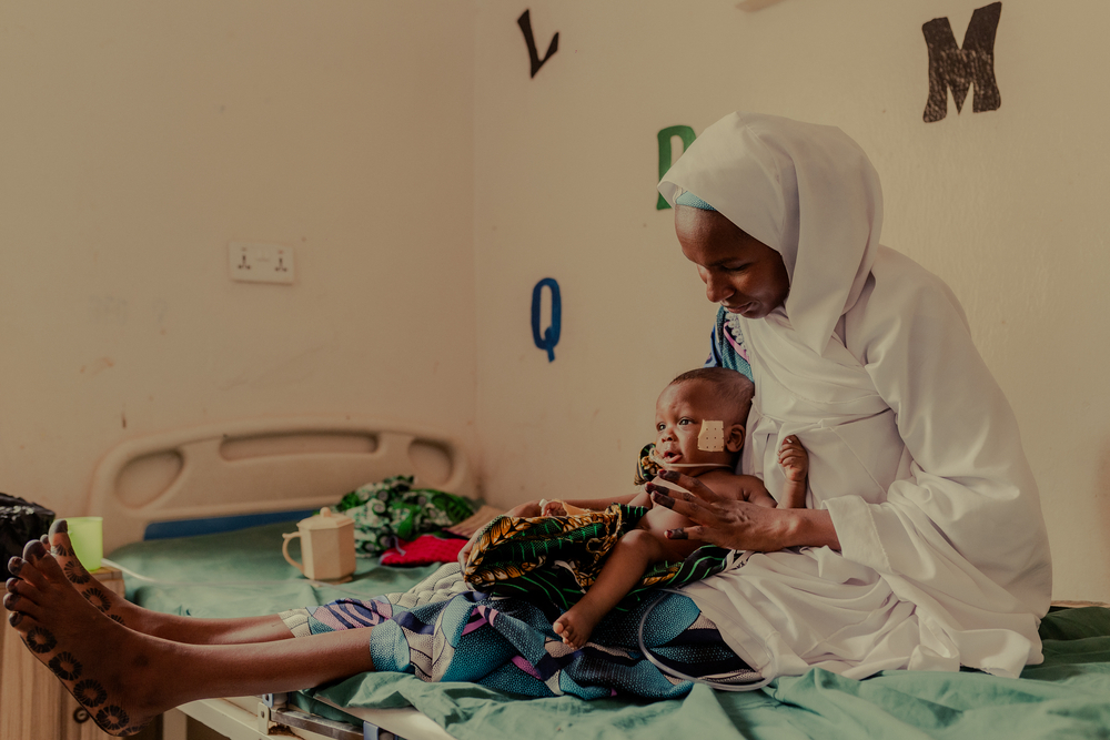 Yusuf Malami, de siete meses, en brazos de su madre, Hadiza Malami. Yusuf, que padece desnutrición, ha estado entrando y saliendo del hospital, pero muestra signos de mejoría. 27 de marzo de 2026 © Nnoli Amarachi