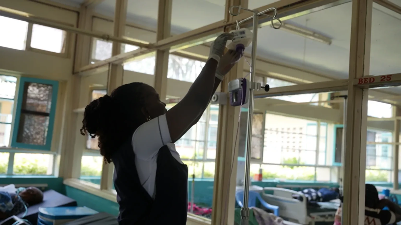 Susan Adingo, enfermera de cuidados paliativos, ajusta la vía intravenosa de un paciente en Homa Bay, Kenia.
