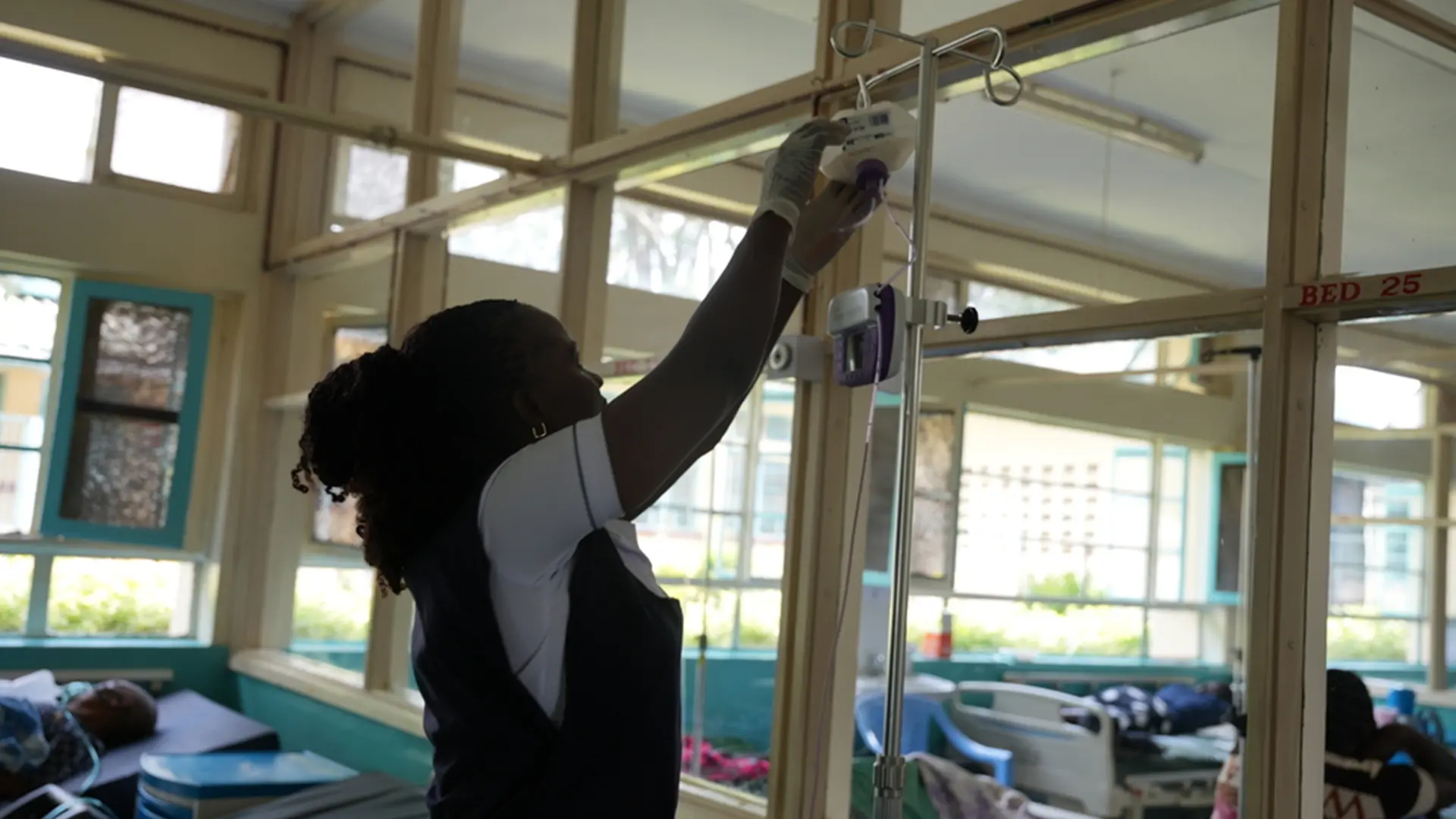 Susan Adingo, enfermera de cuidados paliativos, ajusta la vía intravenosa de un paciente en Homa Bay, Kenia.