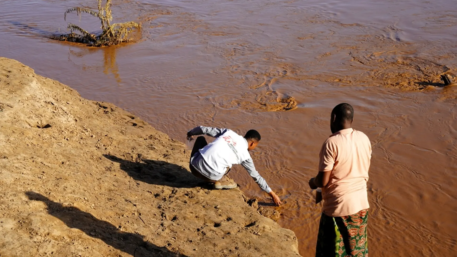 Un miembro del personal de agua y saneamiento de MSF recoge agua del río Shebelle para su análisis en el distrito de Kelafo, región somalí, Etiopía.