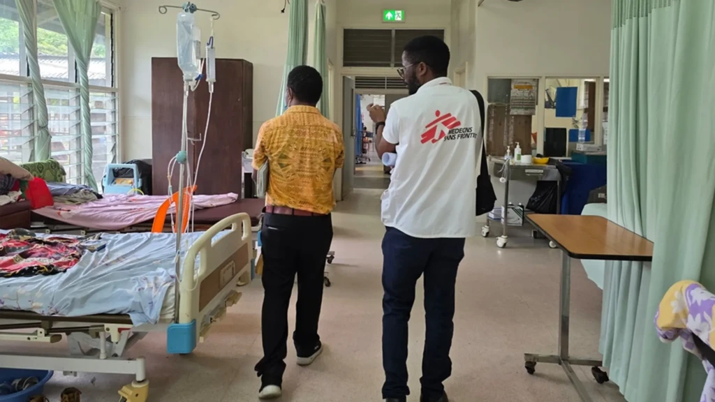 El personal de MSF y un médico del hospital recorren la sala de cuidados en Lae, Morobe.