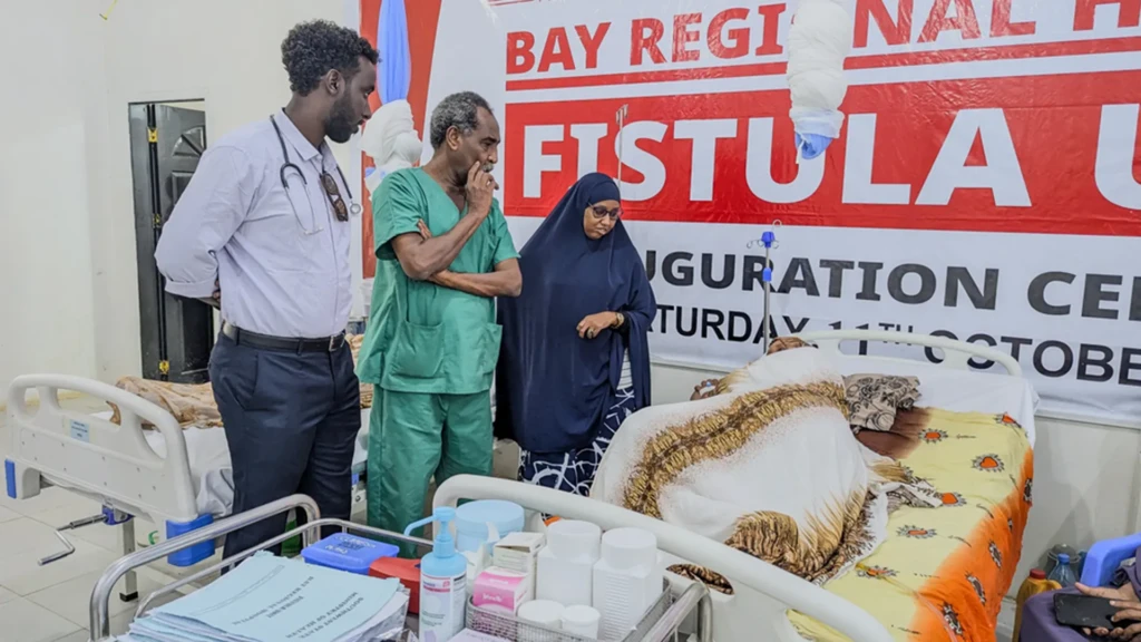 Bishar Awil, anestesista, revisa la historia clínica de una paciente junto con el profesor Elhassan Mohamed, cirujano, y Kalthum Adam, supervisora de la unidad de fístulas, durante la ronda matutina en el Hospital Regional de Bay, en Baidoa, Estado del Suroeste, Somalia.