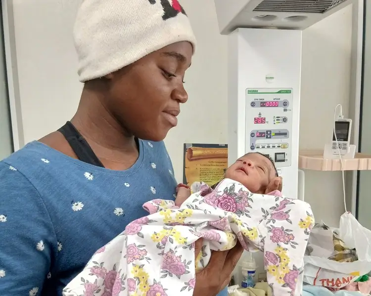 Sterline sostiene a su hija recién nacida tras ser separada de ella durante una evacuación de emergencia causada por la violencia armada en Cité Soleil, Puerto Príncipe, Haití.