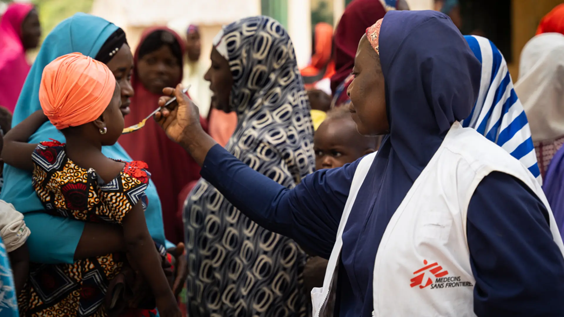 Maryam Muhammad, supervisora de promoción de la salud de MSF en Kebbi, ofrece una cucharada de Tom Brown a un niño durante una demostración de recetas en el pueblo de Maishaka, estado de Kebbi, noroeste de Nigeria.