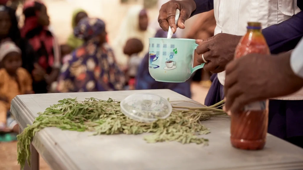 Maryam Muhammad, supervisora de promoción de la salud de MSF en Kebbi, sostiene una taza durante una demostración de recetas de Tom Brown en el pueblo de Maishaika, estado de Kebbi, noroeste de Nigeria. 