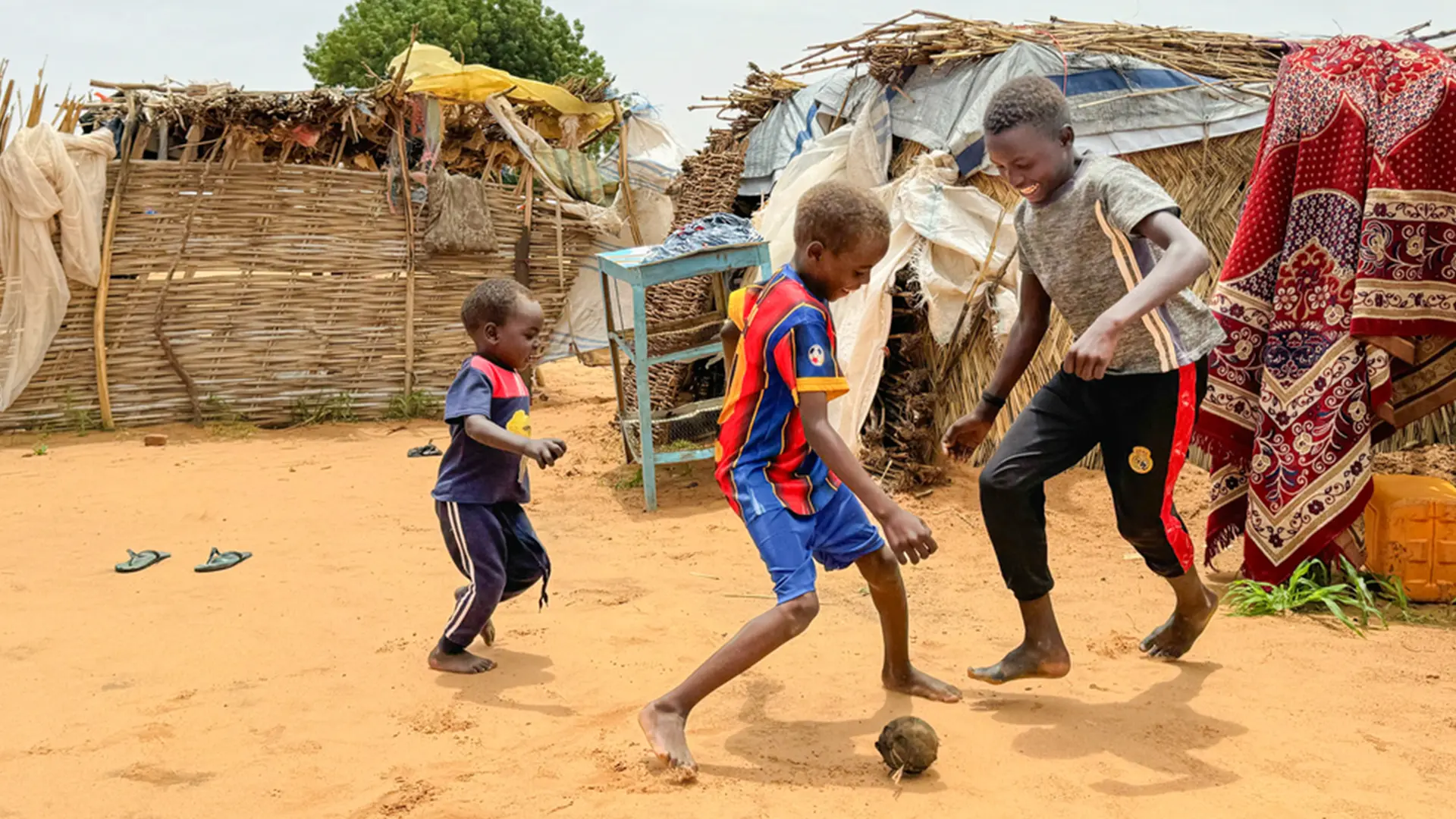 Mazim (a la derecha), de 12 años, juega al fútbol con sus dos hermanos pequeños, con una pelota que fabricaron con un calcetín relleno de bolsas de plástico.
