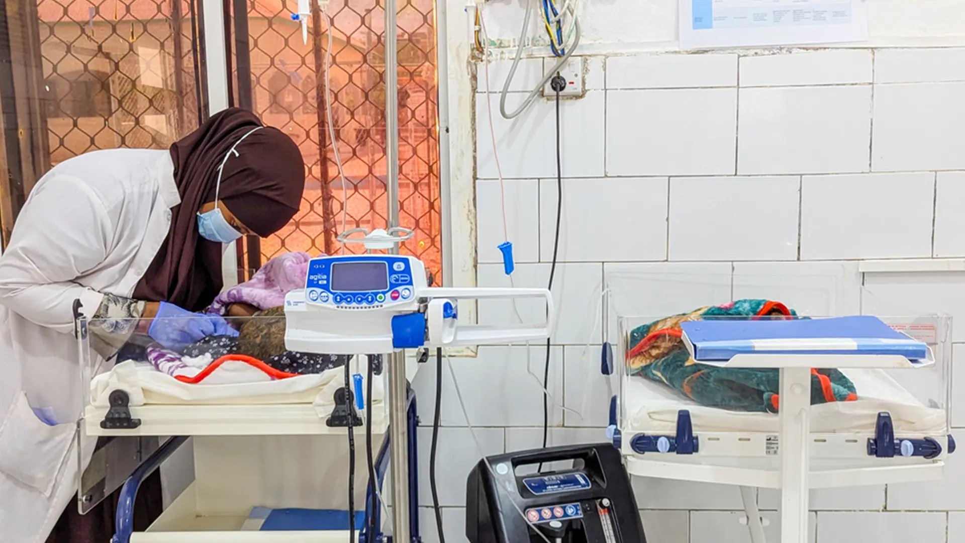 Partera del Hospital Regional Mudug en Galkayo, estado de Puntland, cuida a un recién nacido en la unidad neonatal. Los equipos de monitorización y calentamiento infantil funcionan con una fuente eléctrica que ahora se extrae en gran parte de energía solar.