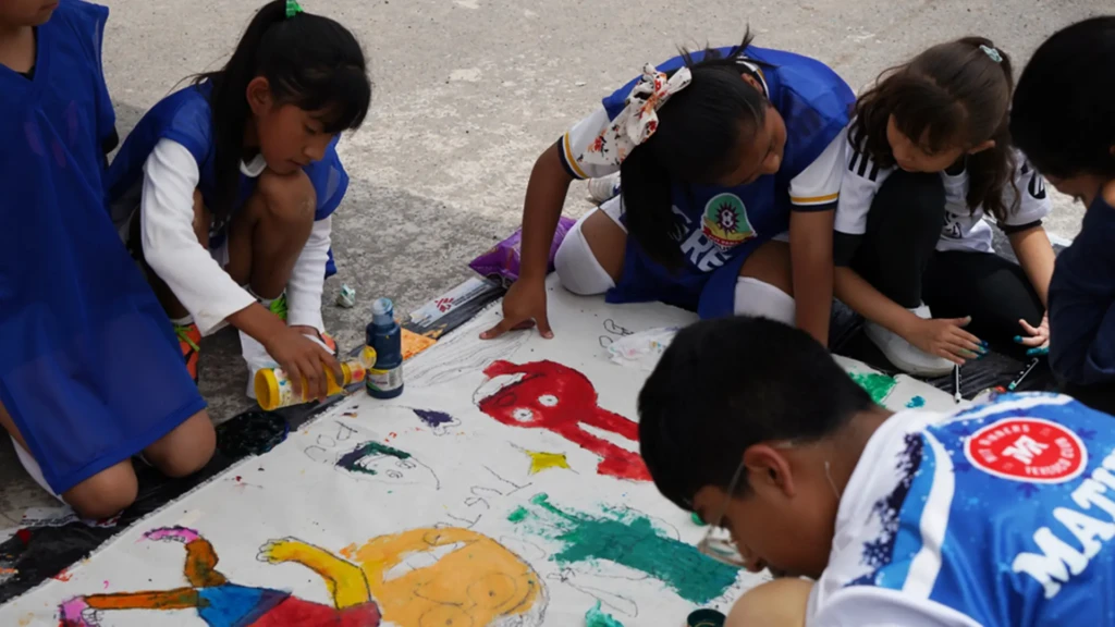 Entre los partidos, algunos niños y niñas trabajaron en un dibujo con un miembro de MSF mientras los promotores de salud hablaban con ellos.