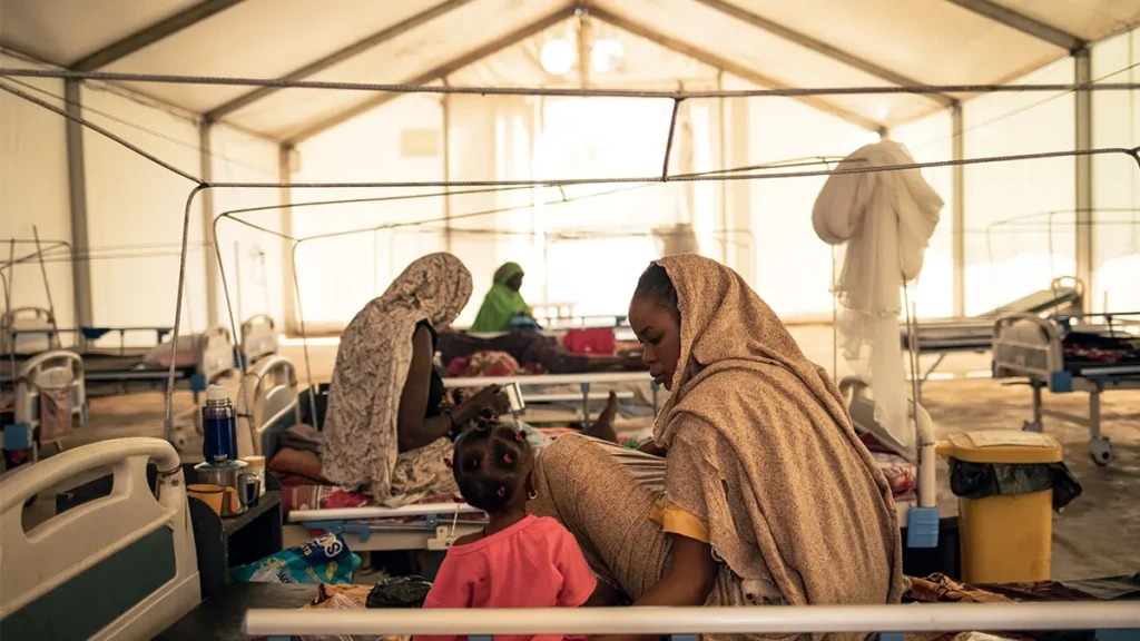 Amna Abderahim, de 21 años, refugiada sudanesa que huyó de las masacres de 2023 en El Geneina (Sudán), observa a su hija Djout Mahamat, de 11 meses. Está siendo tratada por una desnutrición aguda grave con complicaciones en el Centro de Alimentación Terapéutica Hospitalaria (ITFC) gestionado por Médicos Sin Fronteras. Chad. © Alexis Huguet / MSF