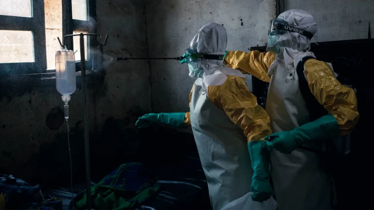Dos higienistas de MSF desinfectan una habitación del Centro de Salud Sayo en Mongbwalu utilizando una solución de cloro después de que fuera ocupada por un paciente con enfermedad confirmada por Ébola.