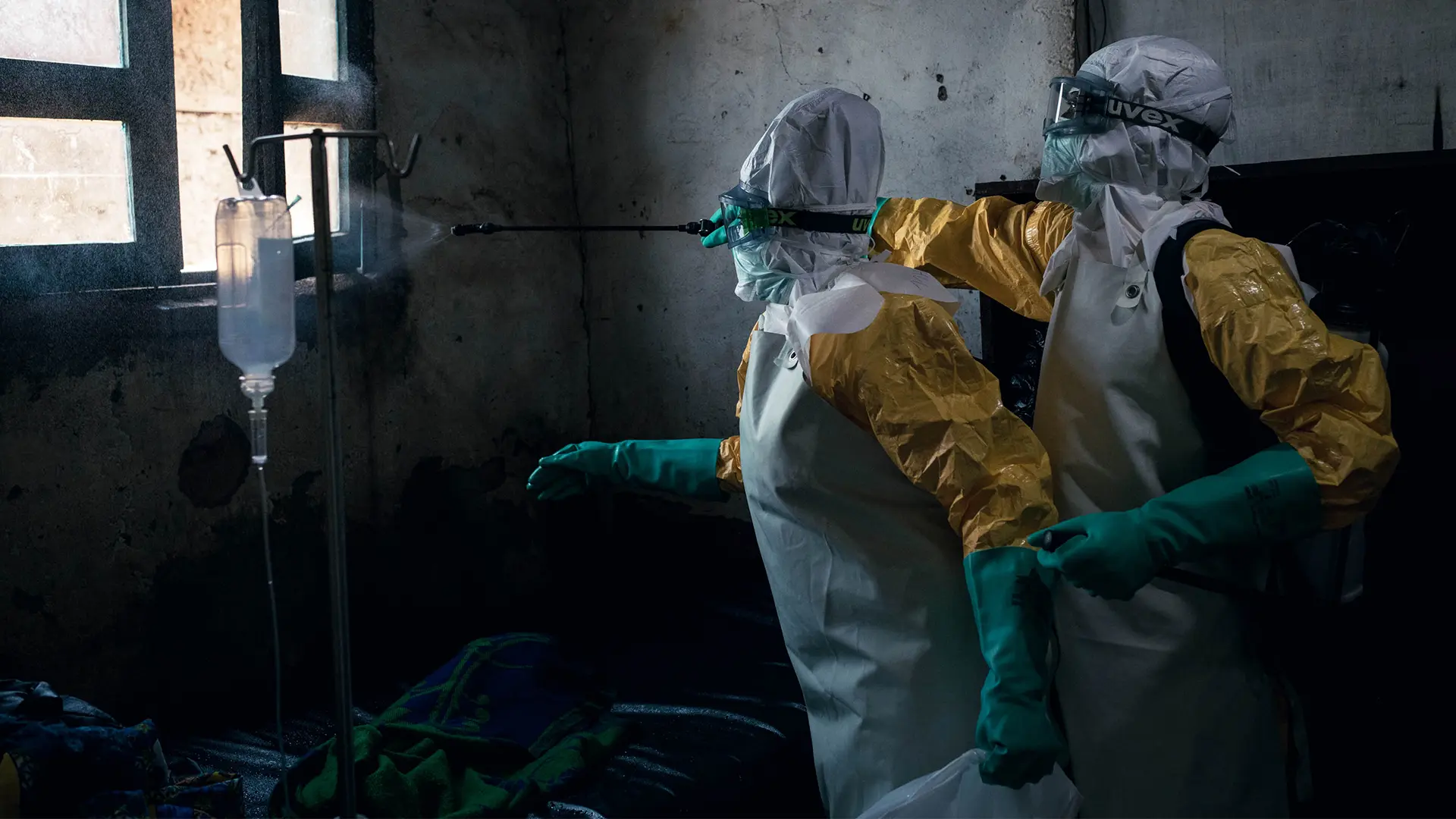 Dos higienistas de MSF desinfectan una habitación del Centro de Salud Sayo en Mongbwalu utilizando una solución de cloro después de que fuera ocupada por un paciente con enfermedad confirmada por Ébola.