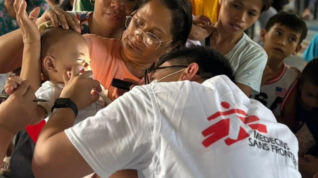 Un trabajador sanitario atiende a un niño en una clínica móvil instalada dentro de una cancha cubierta de baloncesto en la provincia de Sarangani, Mindanao, Filipinas.
