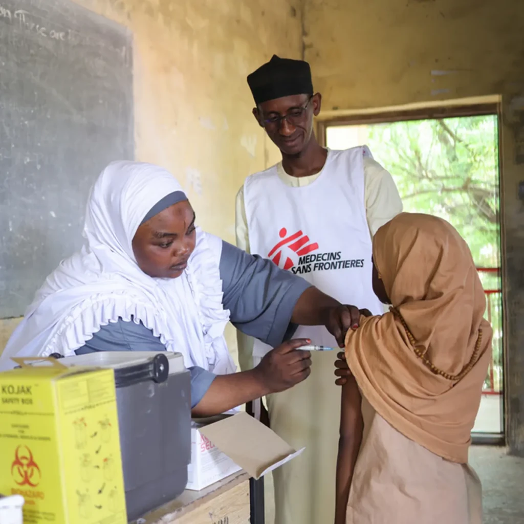 Una enfermera vacuna a una niña en una escuela primaria de Uguwa Uku, en el estado de Kano, al noroeste de Nigeria, durante la campaña de vacunación masiva realizada por Médicos Sin Fronteras en colaboración con el Ministerio de Salud. © Abba Adamu Musa/MSF