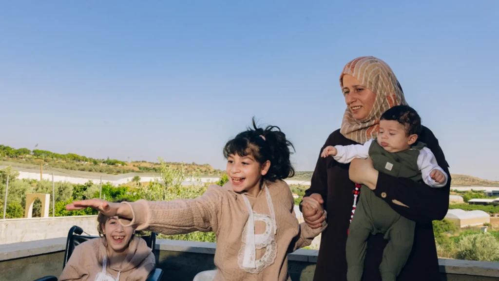 Rana Abu Hajleh con tres de sus hijos en su casa en Azzun Atma, la Cisjordania ocupada. Rana afirma que las restricciones a la movilidad han afectado casi todos los aspectos de la vida familiar, desde la educación hasta el acceso a la atención médica.