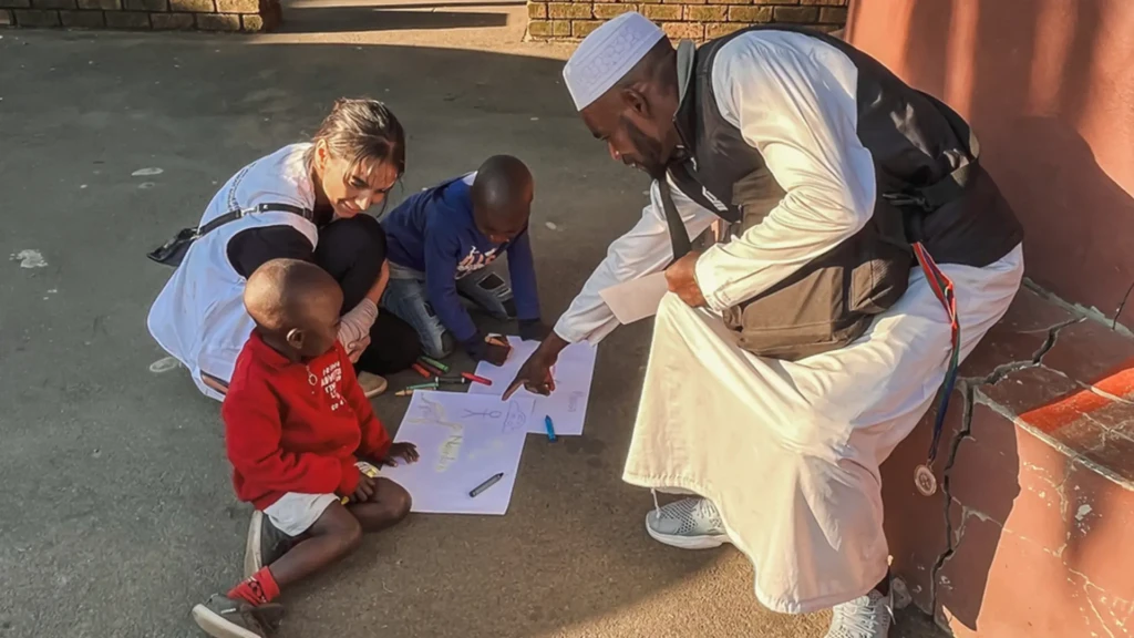 Tasneem Bulbulia, psicóloga de MSF, conduce una sesión de terapia creativa y de apoyo con una familia de Malaui desplazada a causa de los ataques contra los migrantes en Sudáfrica.