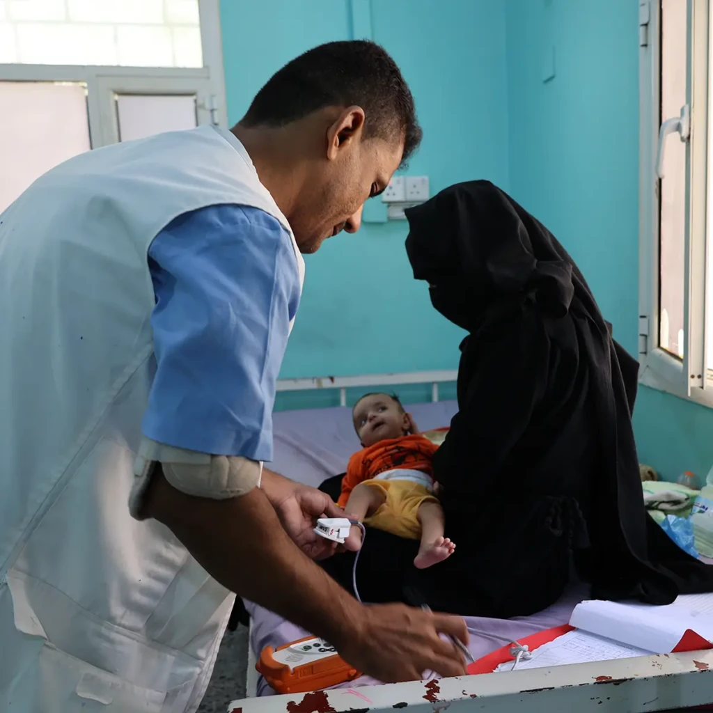 Un miembro del personal del Ministerio de Salud, que recibe apoyo a través del programa de incentivos de MSF, realiza un seguimiento de los niños que muestran signos de recuperación en la sala de pediatría del Hospital General de Abs.