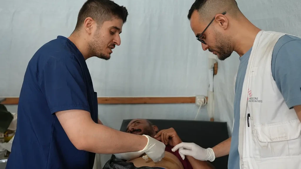 Equipo médico de MSF durante el cambio de vendajes de Ashraf. En Gaza, el personal humanitario sufre la misma violencia que las comunidades a las que apoyan.