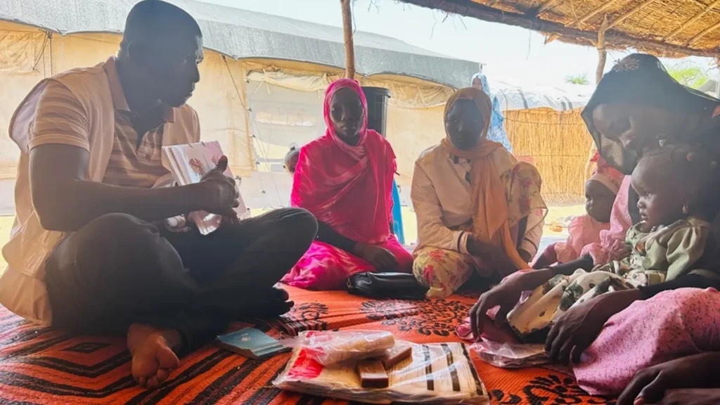 Un Supervisor de Promoción de la Salud de MSF, sensibiliza a las madres sobre las prácticas de higiene mientras esperan su consulta en la clínica móvil instalada en el centro de tránsito de Adémour, en la provincia de Sila, Chad.