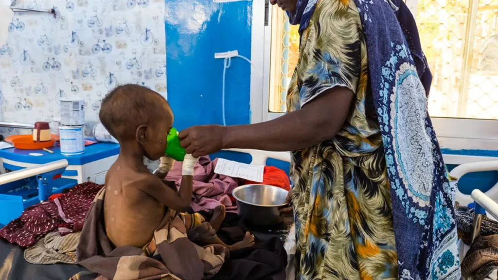 Una madre alimenta a su hijo con desnutrición grave con leche terapéutica en el Centro de Alimentación Terapéutica para Pacientes Hospitalizados (ITFC) del Hospital Regional Bay, apoyado por MSF en Baidoa, Somalia.