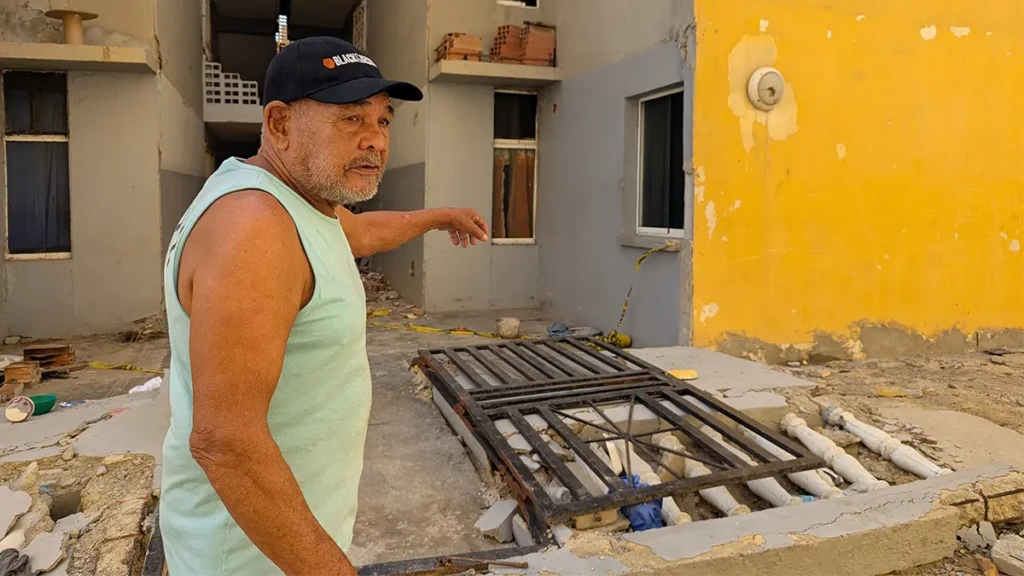 Juan Martínez, paciente de MSF, señala su edificio de departamentos dañado en Mare Abajo, La Guaira. Tras los terremotos del 24 de junio en Venezuela, la estructura se agrietó en dos, obligándole a evacuar su casa en la planta baja.
