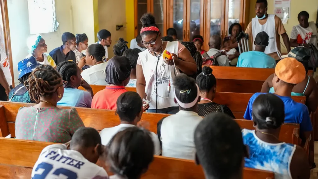 En la sala de espera de una clínica móvil de MSF en Bélair, un barrio de Puerto Príncipe afectado por la violencia armada, una enfermera, Martine Bien-Aimé, toma las constantes vitales de los pacientes.