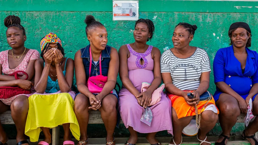 Un grupo de mujeres espera su turno en el patio dentro de la Maternidad Isaïe Jeanty en Cité Soleil, Puerto Príncipe, Haití.