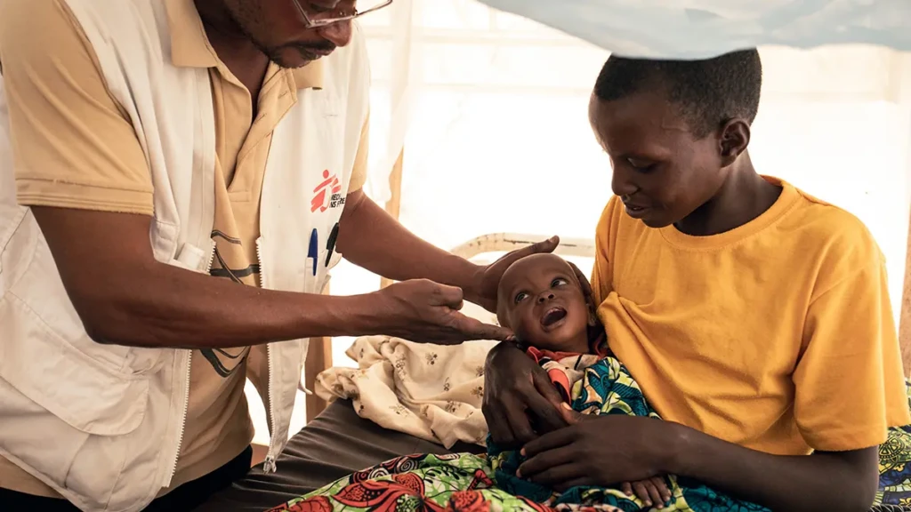 Un médico de MSF examina a Imani, de 9 meses, quien ha sido ingresada en la unidad de alimentación terapéutica intensiva por desnutrición aguda grave en el puesto de salud de MSF del campamento de desplazados internos de Plaine Savo.