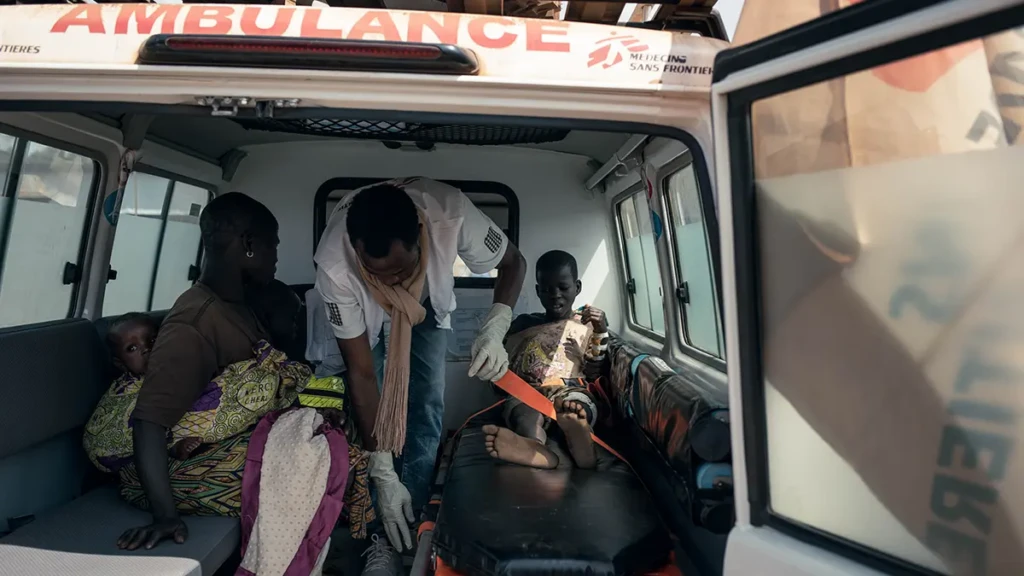 Isaac, de 12 años, está siendo preparado para su traslado en una ambulancia de MSF desde el campo de desplazados internos de Plaine Savo hasta el Hospital General de Referencia de Fataki, situado a unos 15 kilómetros de distancia.