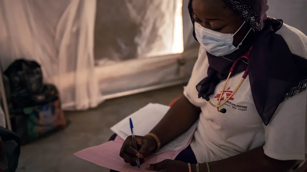 Una doctora de MSF está haciendo una ronda para atender a pacientes en la unidad de aislamiento de sarampión del Hospital Am Timan.