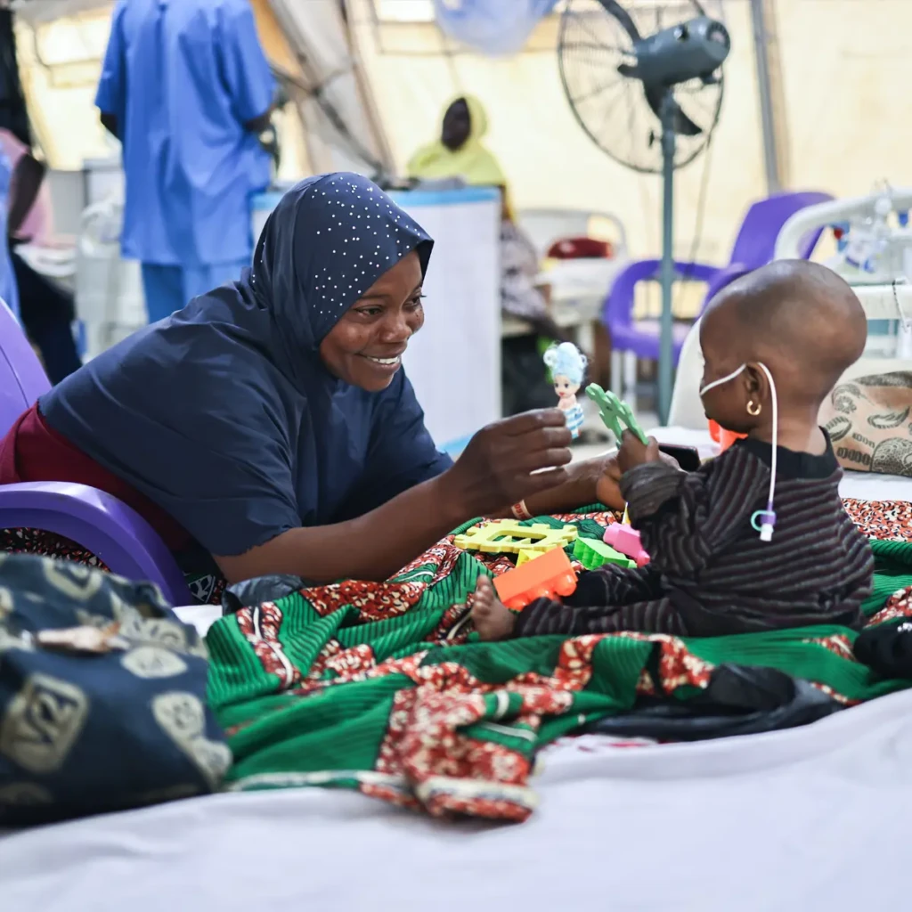 Latifat Abdulkareem juega con su hija de siete meses, Aisha Abdulkareem, quien está ingresada y recibe tratamiento contra la desnutrición en el centro de MSF de Nilefa Kiji, en Maiduguri, Nigeria.